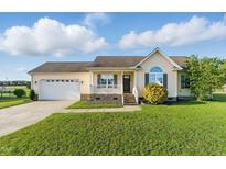 Charming single-story home with a well-manicured lawn, attached garage, and inviting front porch at 108 Hudson Dr, Princeton, NC 27569