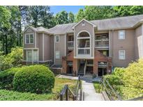 Inviting condo exterior with landscaped entrance and private balconies, nestled among mature trees at 111 Killam Ct # 2A, Cary, NC 27513