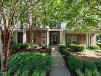 Charming brick townhome featuring a landscaped front yard and inviting entrance, perfect for comfortable living at 1314 Cornell Pl, Raleigh, NC 27607