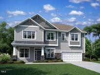Charming two-story home showcasing traditional architecture, manicured lawn, and a two car garage at 1321 Sparkling Lake Dr # 41, Apex, NC 27523