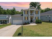 Charming two-story home with a gray exterior, black shutters, and a well-maintained front yard at 187 Ashley Woods Ct, Clayton, NC 27527