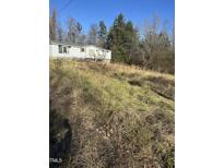 Modest single story house with wooded surroundings at 1916 E Hughes Mill Rd, Burlington, NC 27217