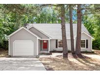 Charming one-story home with gray siding, a red front door, and an attached garage at 20 Meadowcrest Dr, Durham, NC 27703
