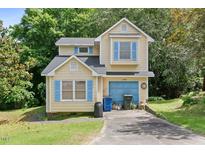 Charming two-story home with light yellow siding, blue shutters, and a single-car garage at 2308 Stonesthrow Ct, Raleigh, NC 27610