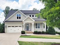 Charming home featuring a covered porch, well-maintained landscaping, and a two-car garage at 2409 Plowridge Rd, Fuquay Varina, NC 27526