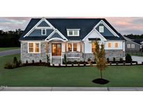 Charming two-story home featuring a stone facade, manicured lawn, and inviting front porch at 249 Lindo Johnson Rd, Pittsboro, NC 27312