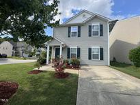 Two-story home with grey siding, front lawn, garden, and concrete driveway at 2612 Beagle Landing Dr, Raleigh, NC 27610