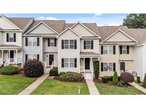 Well-maintained townhouse with neutral siding, black shutters, and a landscaped front yard at 407 Whitehall Ct, Clayton, NC 27520