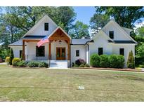 Beautiful two-story white home featuring a welcoming front porch, wood accents and an American flag at 512 Page St, Cary, NC 27511