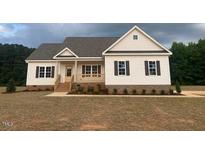 Charming single-story home with white siding, a covered front porch, and a well-manicured lawn at 519 Mulberry Rd, Spring Hope, NC 27882