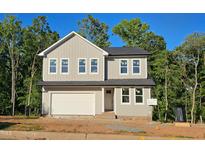 Charming two-story home features a grey exterior, black roof, a 2-car garage, and manicured landscaping at 633 Conover Rd, Durham, NC 27703