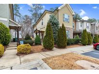 A view of the townhome's facade, with landscaped front yard, sidewalk and partial view of adjacent home at 752 Wickham Ridge Rd, Apex, NC 27539