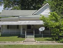 Charming home featuring a welcoming front porch, complemented by verdant landscaping and a well-maintained lawn at 824 Beal St, Rocky Mount, NC 27804