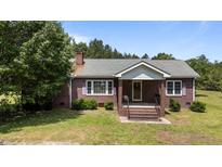 Charming brick home with a cozy front porch and well-maintained landscaping at 1131 Pulley Gordon Rd, Zebulon, NC 27597