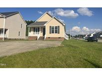 Charming single-Gathering home boasts a welcoming front porch and ample parking on a well-manicured lawn at 12 Linsey Ct, Lillington, NC 27546