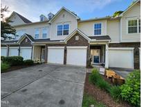 Inviting townhouse exterior with stone accents, attached garages, and landscaped front yard at 1309 Bartlett Cir, Hillsborough, NC 27278