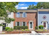 Traditional red brick townhouse with gray shutters, manicured front garden, and walkway to gray front door at 1344 Baez St, Raleigh, NC 27608