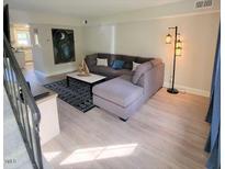 Living room with a large sectional sofa, decorative lighting, and modern decor that create an inviting atmosphere at 141 Jones Franklin Rd # E, Raleigh, NC 27606
