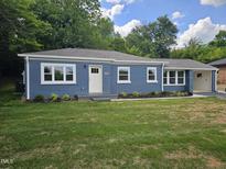 Charming blue brick ranch-style home with a well-manicured lawn and white trim at 1917 Tucker St, Burlington, NC 27215