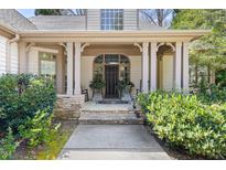 Inviting covered front entrance featuring stone accents, stately columns, and rocking chairs for relaxing at 20007 Bragg, Chapel Hill, NC 27517