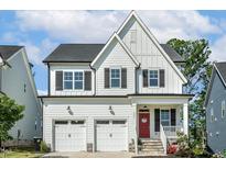 Charming two-story home featuring a two-car garage, a red front door, and a well-manicured lawn at 208 Dry Canyon Dr, Wendell, NC 27591
