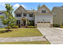 Charming two-story home showcasing a well-maintained lawn and attached two-car garage at 2135 Vittorio Ln, Apex, NC 27502