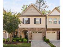 Charming two-story townhome featuring a stone facade, attached garage, and professionally landscaped front yard at 2242 Sweet Annie Way, Wake Forest, NC 27587