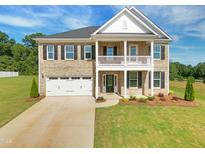 Stunning two-story brick home with a welcoming front porch and well-manicured lawn, complete with an attached two-car garage at 3002 Dog Rose Dr # 310, Durham, NC 27703