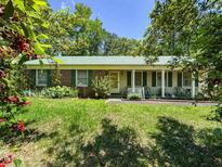 Charming single-story home with a well-manicured lawn and a welcoming front porch and green shutters at 305 Reynolds N Ave, Durham, NC 27707