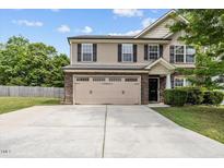 Charming two-story home with a stone accent, tan siding, attached two car garage, and well-kept lawn at 3169 Diana Cir, Burlington, NC 27215