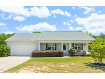 Charming single-story home with well-maintained lawn and inviting front porch, complemented by lush landscaping at 357 Sherrill Farm Dr, Benson, NC 27504