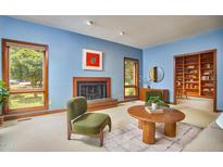 Bright living room featuring hardwood floors, a fireplace, and large windows with natural light at 37 Wedgewood Rd, Chapel Hill, NC 27514