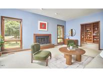 Inviting living room features a cozy fireplace, built-in bookshelves, and bright windows at 37 Wedgewood Rd, Chapel Hill, NC 27514