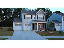 Charming two-story home boasts a two-car garage, covered porch, and well-maintained landscaping at 391 Curling Creek Dr Dr, Clayton, NC 27527