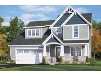 Inviting home showcasing stone accents, a two-car garage, and manicured lawn under a bright blue sky at 40 W Victoria Ridge Dr # 18, Selma, NC 27576