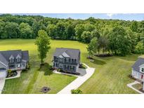 Beautiful home with a large yard, long drive, and lush greenery and trees at 45 Leighann S Ct, Timberlake, NC 27583