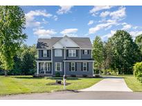 Beautiful two-story home featuring gray siding, black shutters, a well-manicured lawn and a concrete driveway at 45 Leighann S Ct, Timberlake, NC 27583