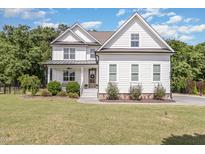 Beautiful two-story white farmhouse-style home with well-maintained lawn and landscaping creating a welcoming curb appeal at 5180 Old Powell Rd, Holly Springs, NC 27540