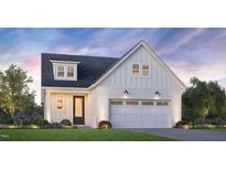 Charming new construction featuring white brick and siding, a two-car garage, and a welcoming front yard at 5217 Bowes Meadow Ct # 14, Raleigh, NC 27610