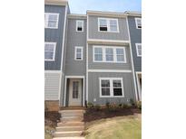 Charming three-story townhome featuring a classic design, inviting entrance, and well-maintained landscaping at 805 Hyperion Aly, Wake Forest, NC 27587