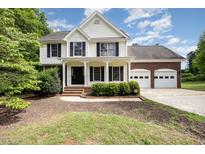 Charming two-story home featuring a covered porch and a two-car garage at 84 Sycamore Lake Rd, Siler City, NC 27344