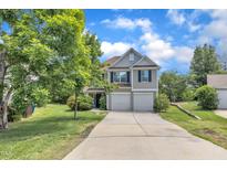 Charming two-story home with a two car garage, manicured lawn and a beautiful blue sky at 10 Marsh Landing Ct, Durham, NC 27703