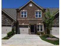 Charming townhome featuring a brick facade, attached garage, and manicured front lawn at 1033 Talisker Way # 16, Burlington, NC 27215