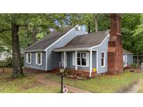 Charming home showcasing grey siding, brick chimney and a delightful front garden at 1100 Cardinals Knob, Rocky Mount, NC 27804