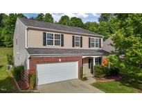 Charming two-story home with brick accents, a two-car garage, and manicured landscaping at 1301 Torrey Pines Ct, Mebane, NC 27302