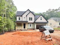 New construction two-story home with green siding, stone accents, and attached two-car garage at 188 Buckaroo Dr, Louisburg, NC 27549