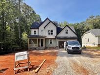 Charming new construction home with craftsman details, set among mature trees, and a well-lit front yard at 188 Buckaroo Dr, Louisburg, NC 27549