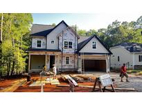 New construction featuring a two-story home with an attached two-car garage in a wooded setting at 188 Buckaroo Dr, Louisburg, NC 27549