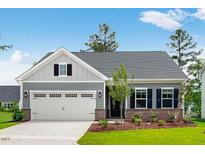 Charming single-story home with a two-car garage, a manicured lawn, and brick accents at 2021 Clydner Dr, Apex, NC 27523