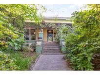 Charming home exterior with a welcoming front porch covered in flowering vines and lush landscaping at 206 N State St, Raleigh, NC 27601
